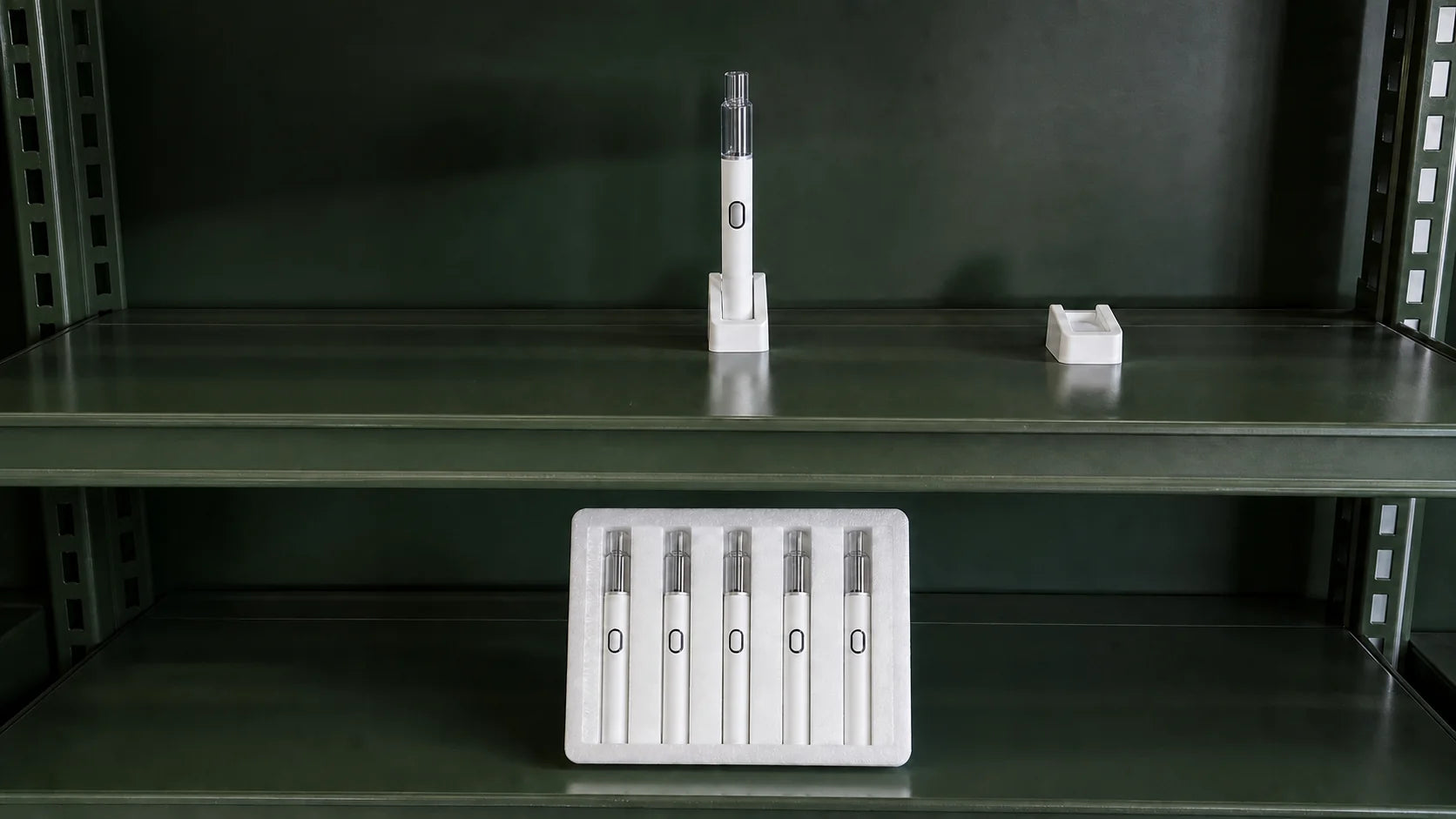 One empty Briar device sits in a fitted shelf cradle beside an empty candidate cradle, with a five-unit pack on the shelf below.
