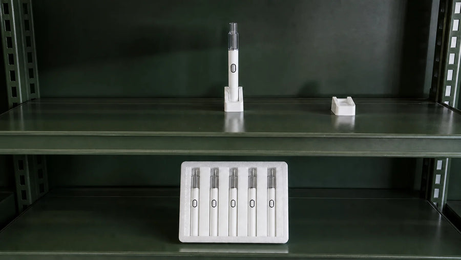 One empty Briar device sits in a fitted shelf cradle beside an empty candidate cradle, with a five-unit pack on the shelf below.
